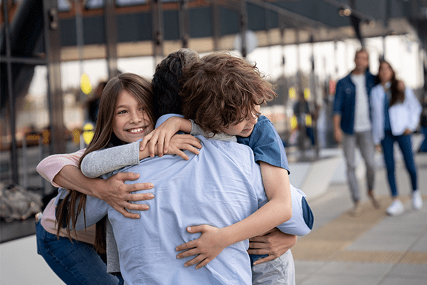 Children hugging their father