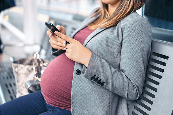 Pregnant mother texting coparent