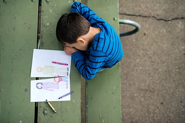 Young boy coloring on a picnic table