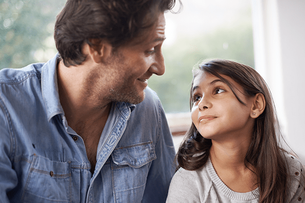 Man and little girl making faces at each other