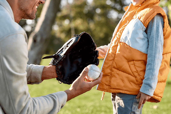 Father handing son a baseball