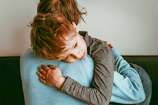 Sad child hugging father