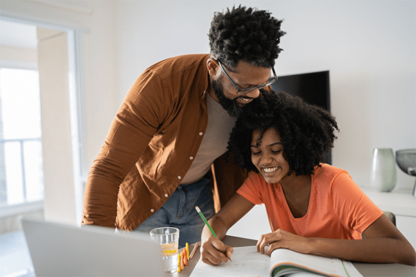 Father helping teenage daughter with homework