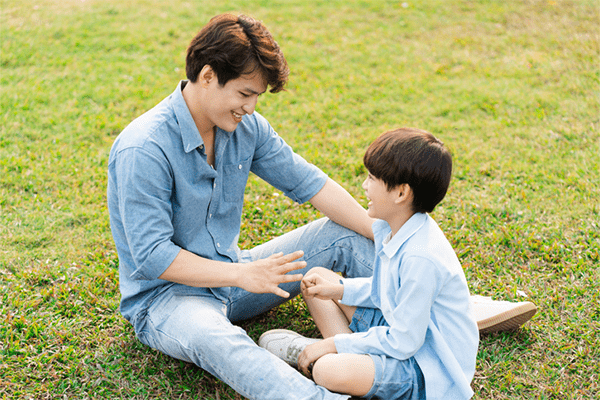 Father sitting with son in park