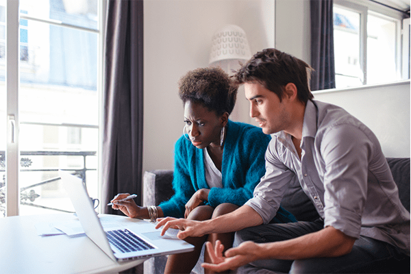 Man and woman looking over documents on a computer