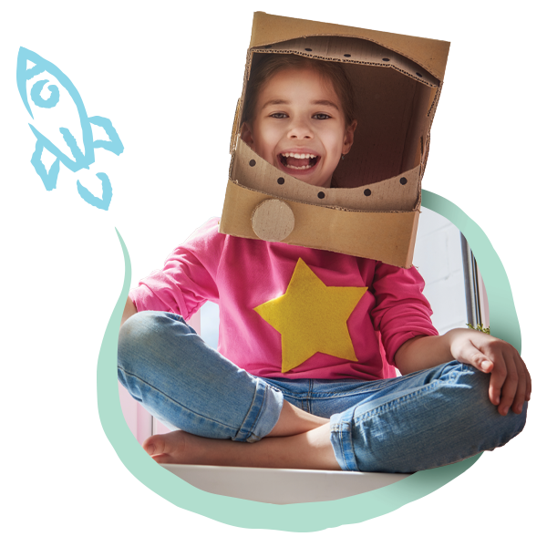 Child sitting playfully with a box on her head